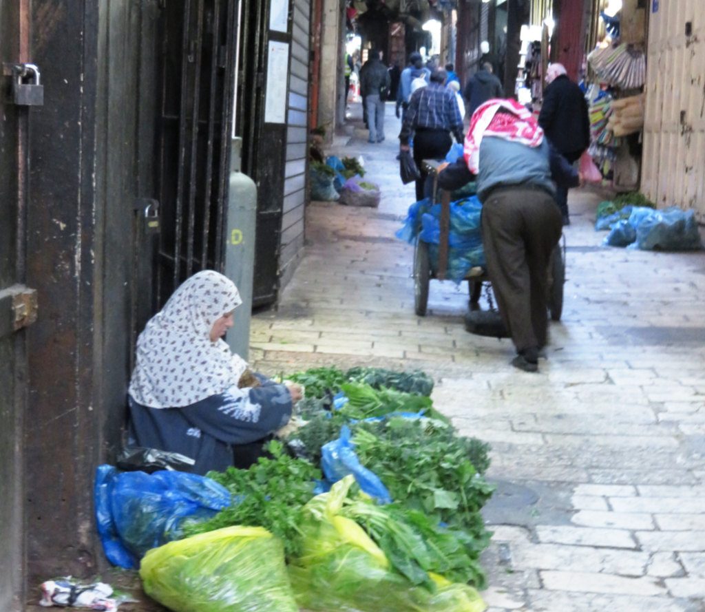 A woman chopping and selling herbs on a Jerusalem high street-the diversity of Jerusalem. Photo by: Joshua Stein.